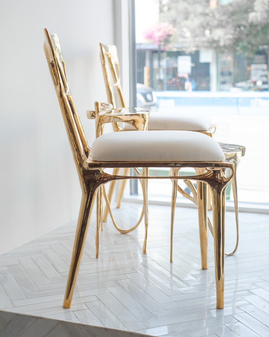 CONTEMPORARY POLISHED CAST BRASS CHAIR WITH UPHOLSTERED CALICO SEAT