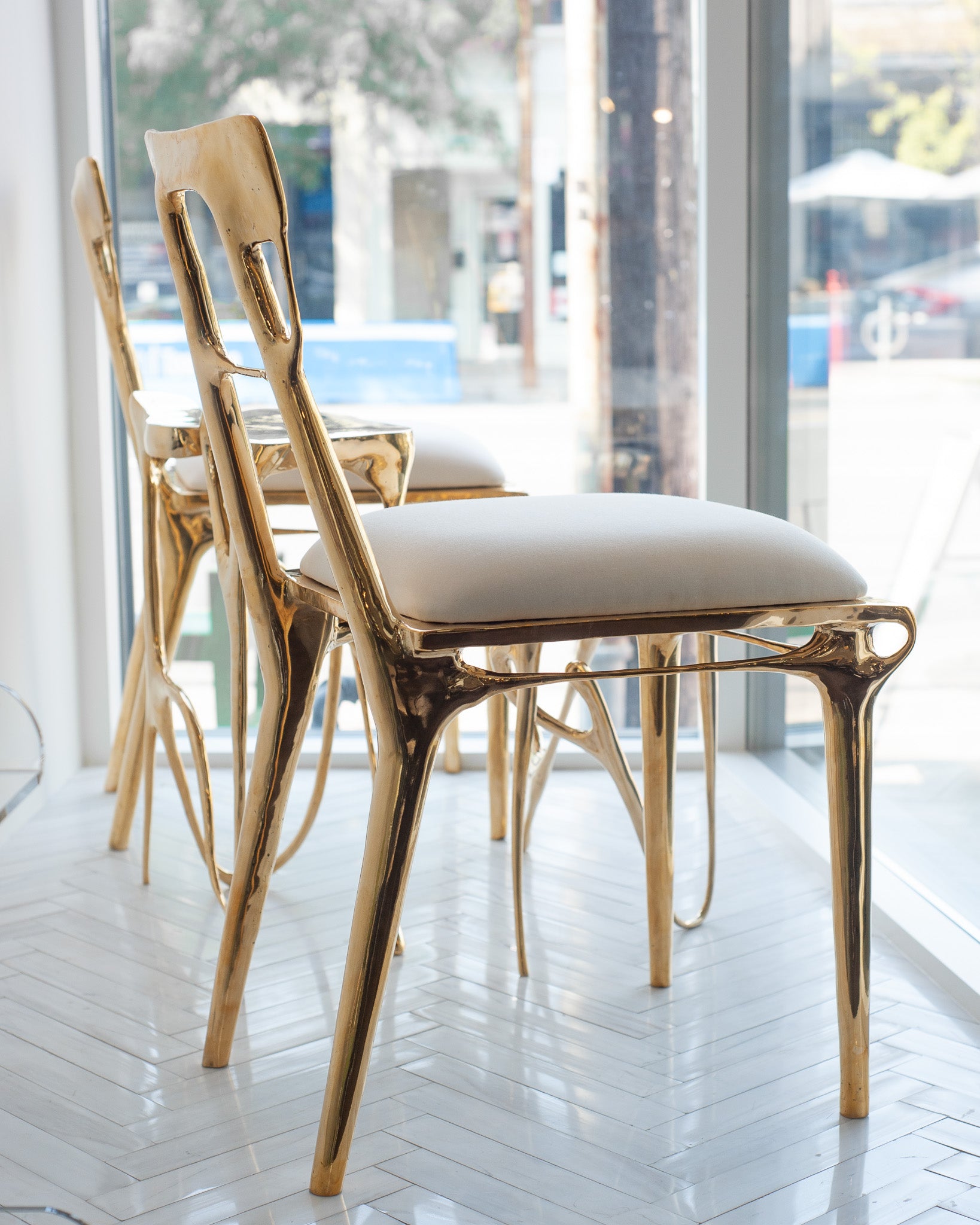 CONTEMPORARY POLISHED CAST BRASS CHAIR WITH UPHOLSTERED CALICO SEAT