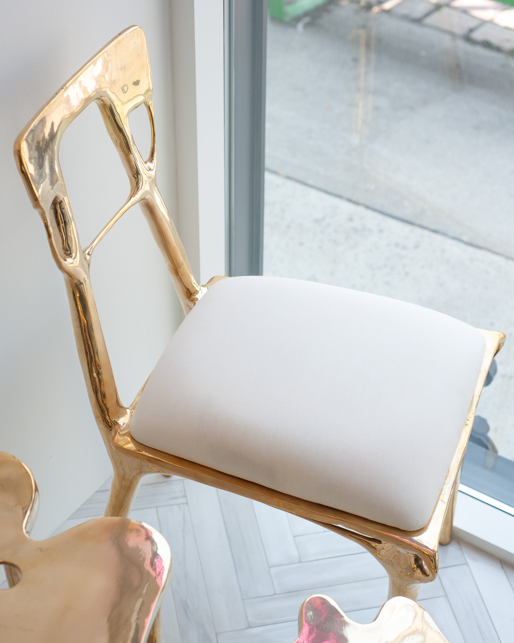 CONTEMPORARY POLISHED CAST BRASS CHAIR WITH UPHOLSTERED CALICO SEAT