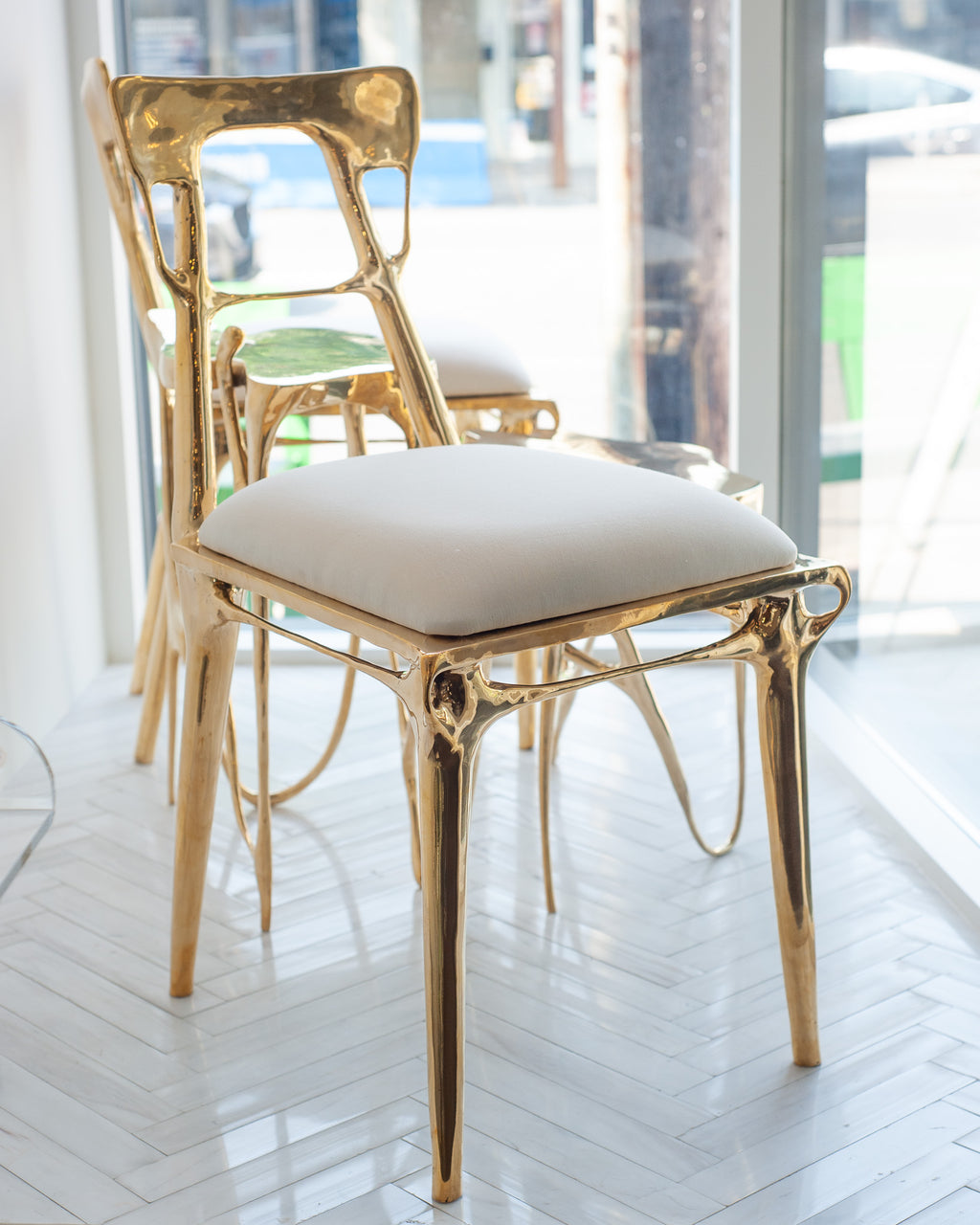 CONTEMPORARY POLISHED CAST BRASS CHAIR WITH UPHOLSTERED CALICO SEAT