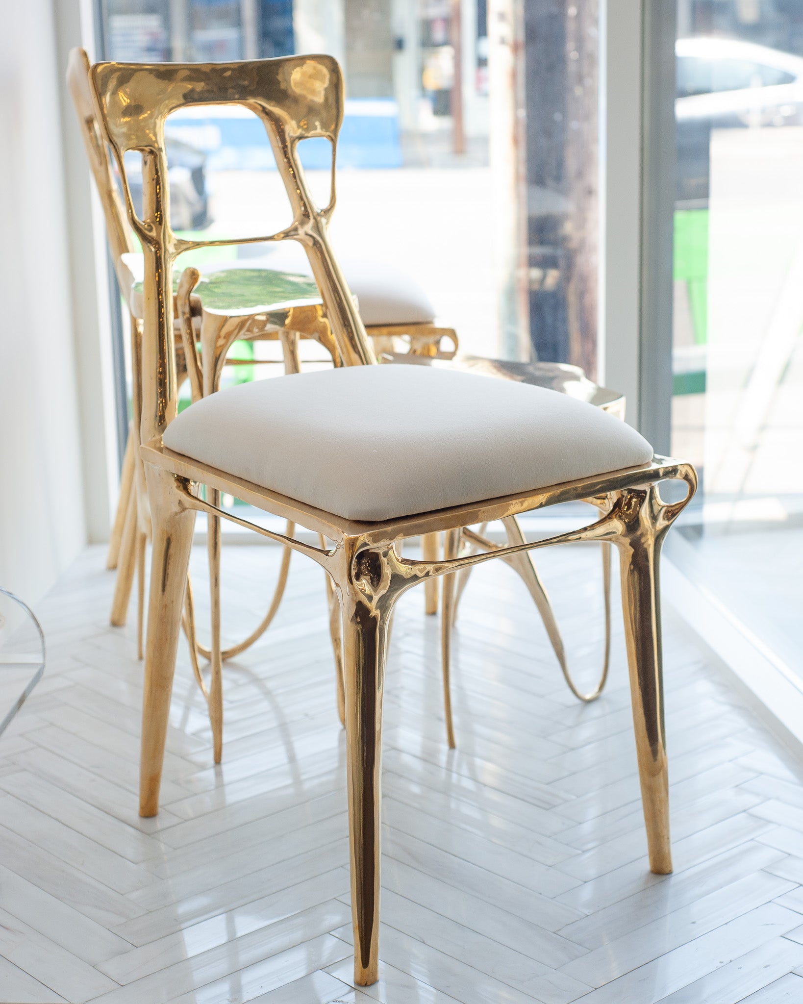 CONTEMPORARY POLISHED CAST BRASS CHAIR WITH UPHOLSTERED CALICO SEAT