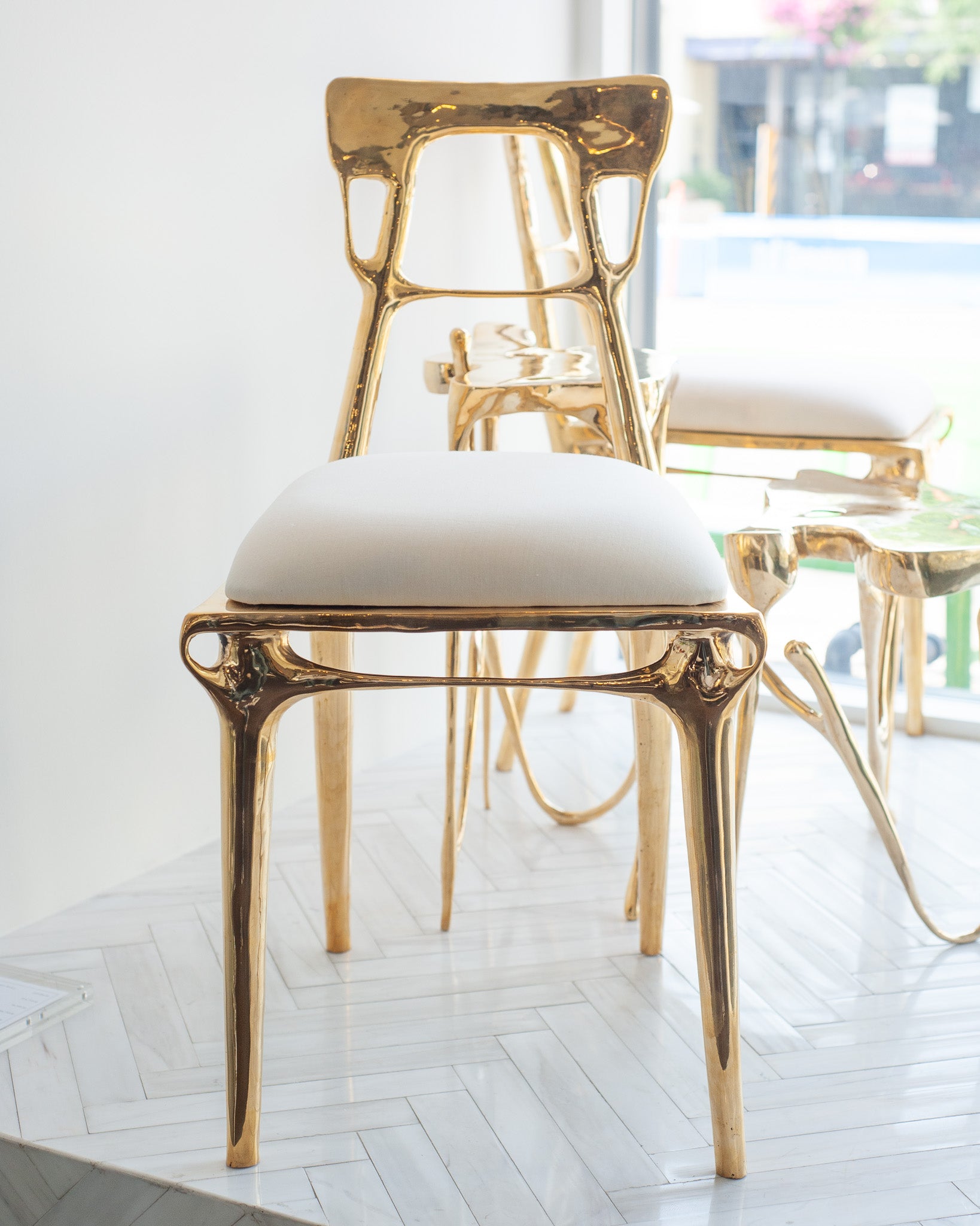 CONTEMPORARY POLISHED CAST BRASS CHAIR WITH UPHOLSTERED CALICO SEAT