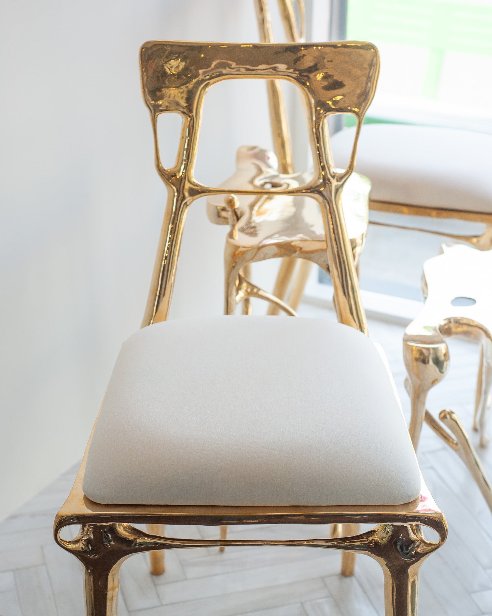 CONTEMPORARY POLISHED CAST BRASS CHAIR WITH UPHOLSTERED CALICO SEAT