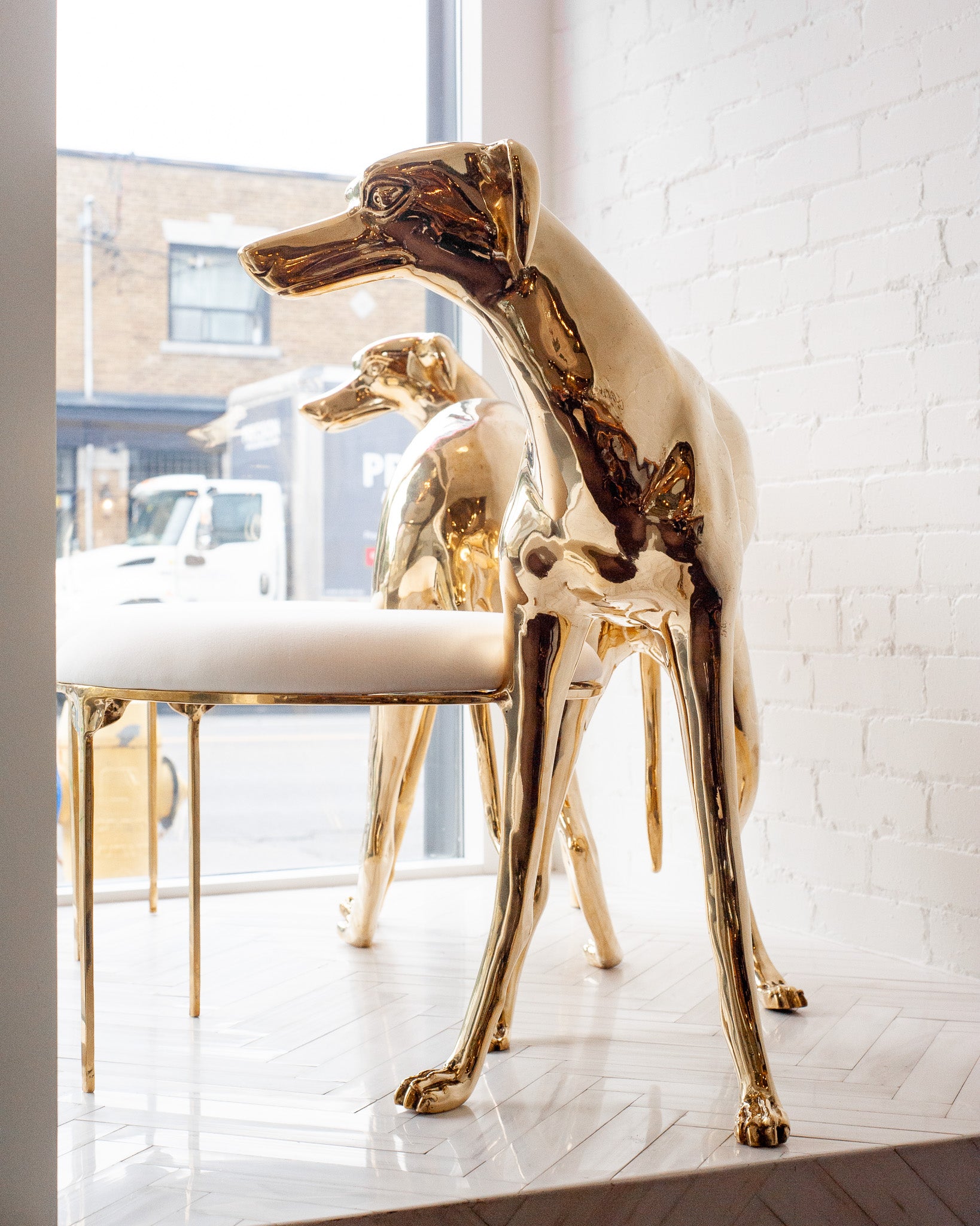 CONTEMPORARY PAIR OF POLISHED CAST BRASS GREYHOUND CHAIRS