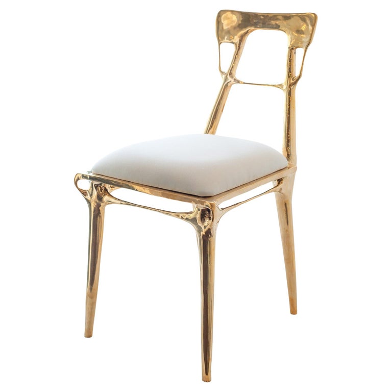 CONTEMPORARY POLISHED CAST BRASS CHAIR WITH UPHOLSTERED CALICO SEAT