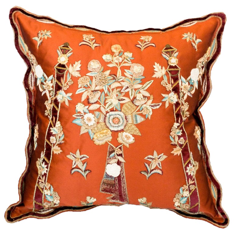 FLORAL METALLIC EMBROIDERY ON A RED SATIN PILLOW