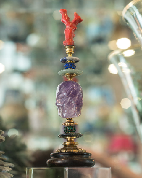 A one of a kind sculptural objet consisting of a carved Amethyst skull with an authentic coral branch, semi-precious stones and antique bronze components on a painted wood pedestal by German artist, Dupont.