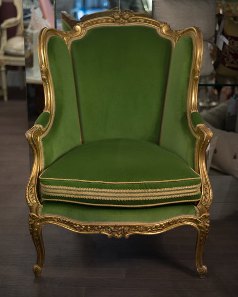 This elegant and comfortable French Antique Bergère chair is expertly re-upholstered in a vibrant and modern shade of green cotton velvet and finished with metallic trim. The frame has been entirely re gilded.