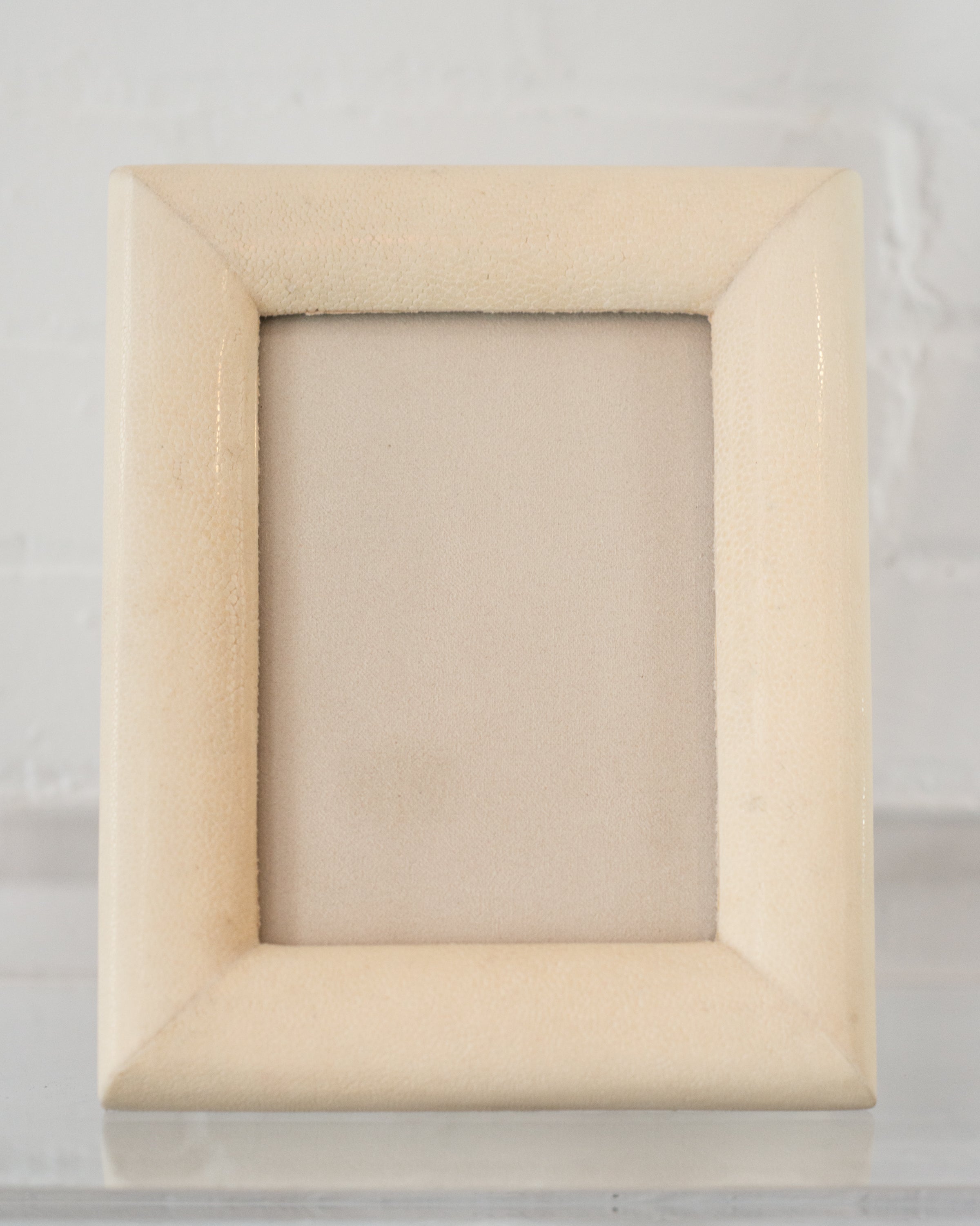 A medium picture frame in crème Shagreen & walnut,  backed in suede.