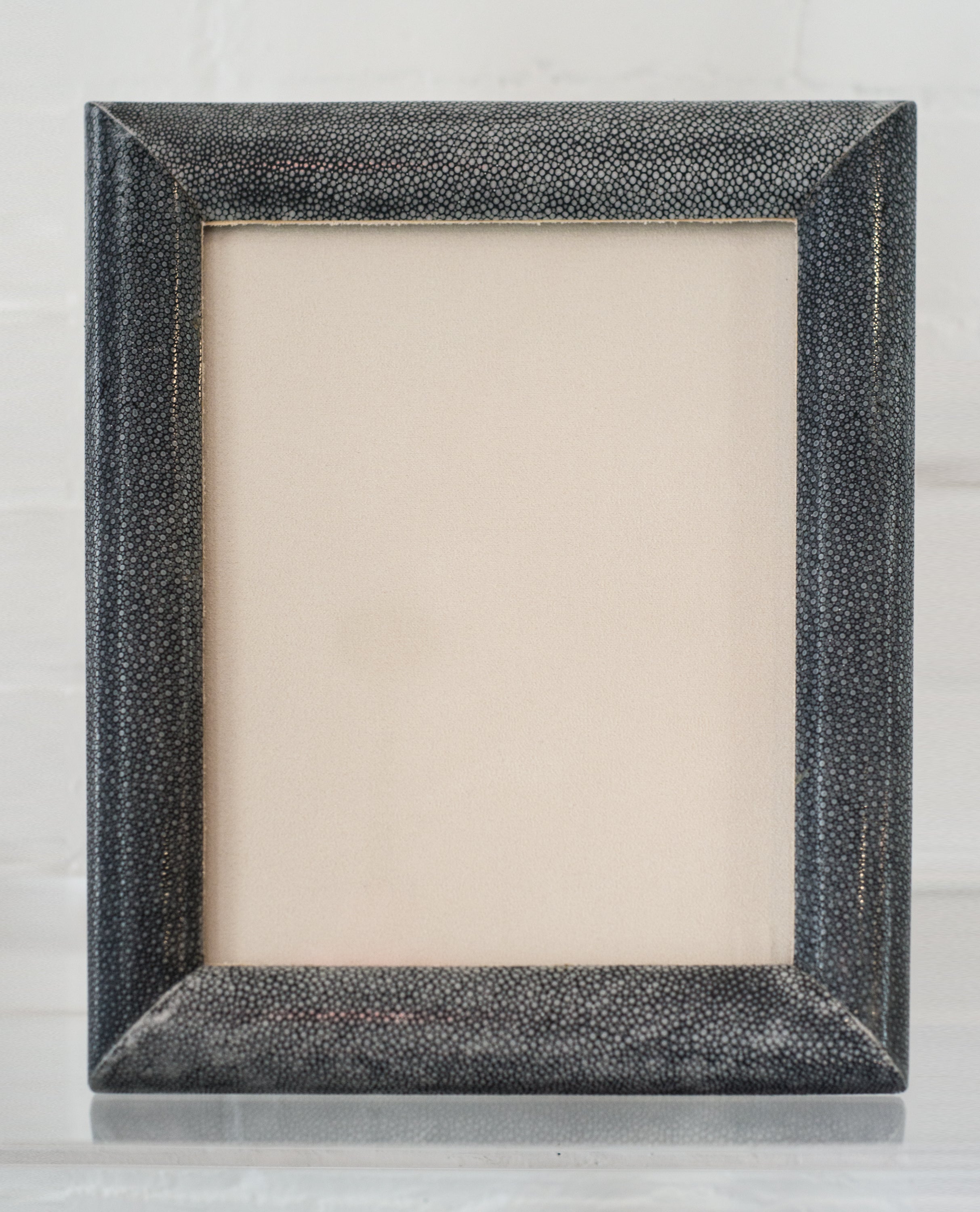 A large picture frame in blue/black Shagreen & walnut, backed in suede.