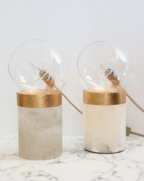 A pair of small lamps on solid quartz bases with glass domes and brass details. Suitable for a desk, night stands or end tables.