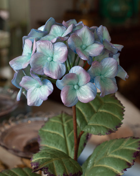 PORCELAIN GLAZED PURPLE AND BLUE HYDRANGEA IN A WICKER POT